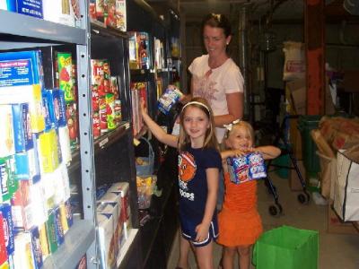 Mia and family stocking pantry shelves
